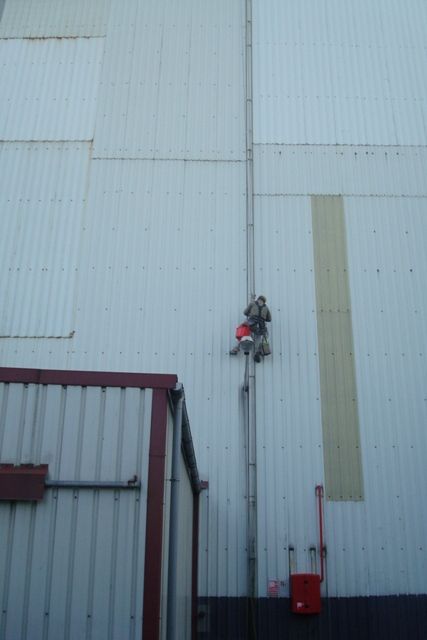 Imagen de trabajador en fachada de nave de Repsol