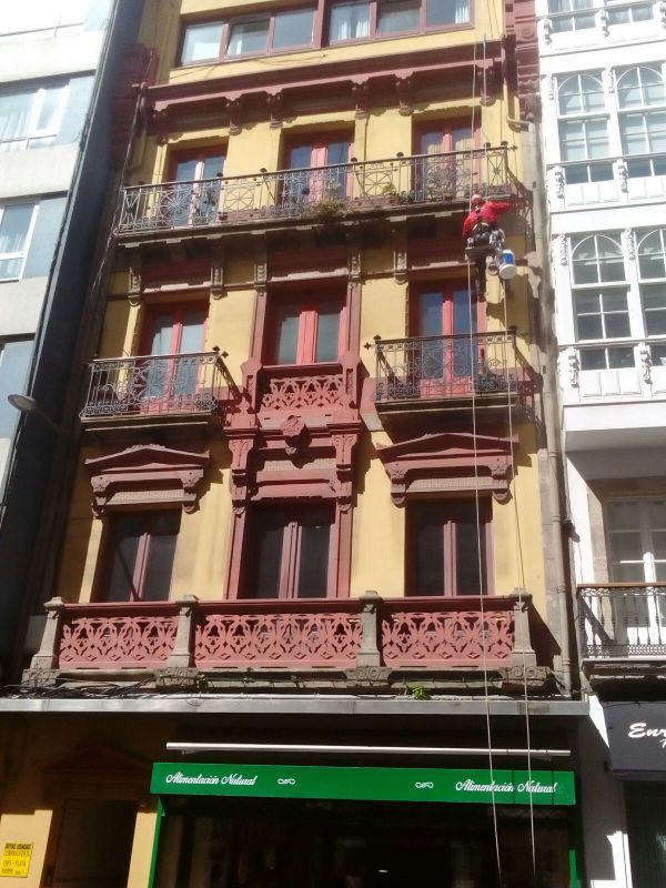 Trabajador realizando la restauración de unas mensulas de piedra en fachada de edificio