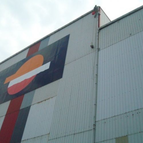 Imagen de fachada de nave de Repsol con lona grande con logotipo