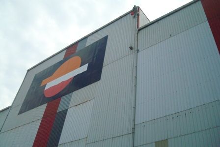 Imagen de fachada de nave de Repsol con lona grande con logotipo