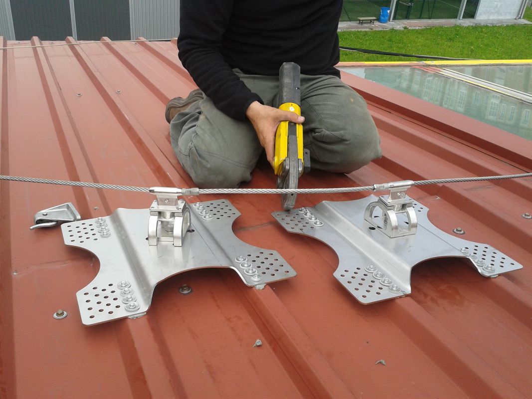 Imagen de trabajador grapando líneas de vida en tejado