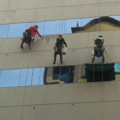 Trabajadores en altura limpiando la fachada del Hotel Hesperia en A Coruña