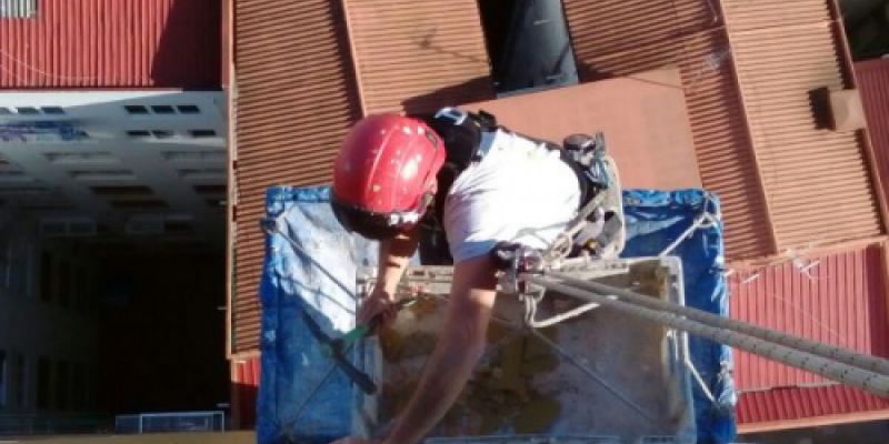 Imagen de trabajador realizando restauración en fachada de la Torre Dorada