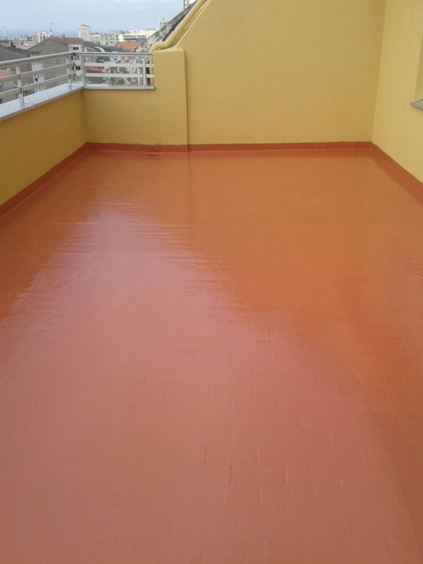 Imagen de suelo de color rojo impermeabilizado en terraza con paredes amarillas