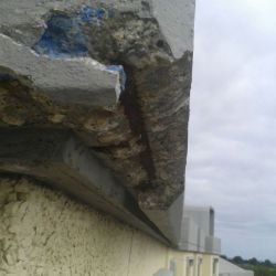 Imagen de cornisa de hormigón deteriorada con piezas sueltas retiradas