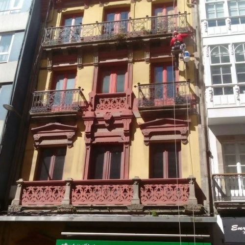 Trabajador realizando la restauración de unas mensulas de piedra en fachada de edificio