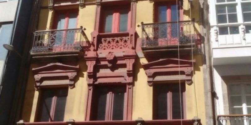 Trabajador realizando la restauración de unas mensulas de piedra en fachada de edificio