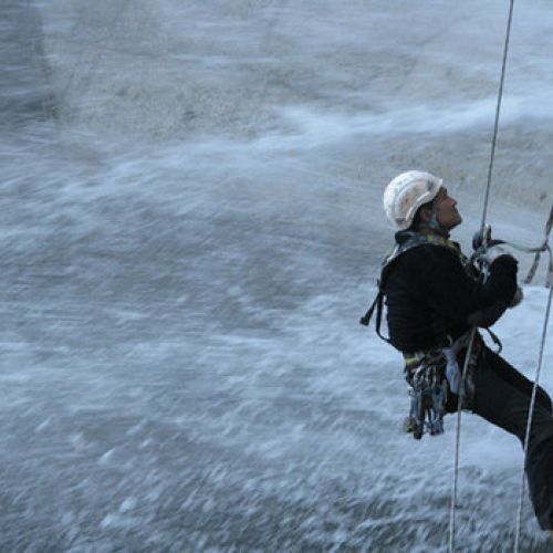 Imagen de trabajador colgado el altura con arneses en presa