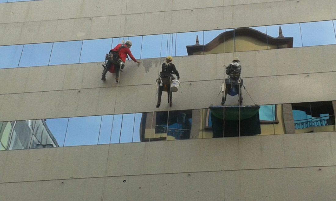 Trabajadores en altura limpiando la fachada del Hotel Hesperia en A Coruña