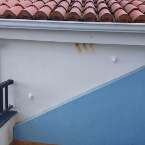 Imagen de tubo rectangular de color blanco en salida de humos junto a tejado