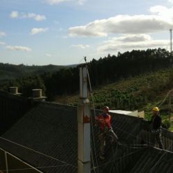 Trabajador colocando chimenea en tejado de edificio