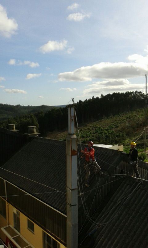 Trabajador colocando chimenea en tejado de edificio