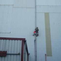 Imagen de trabajador en fachada de nave de Repsol